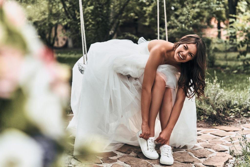 bride putting on tennis shoes