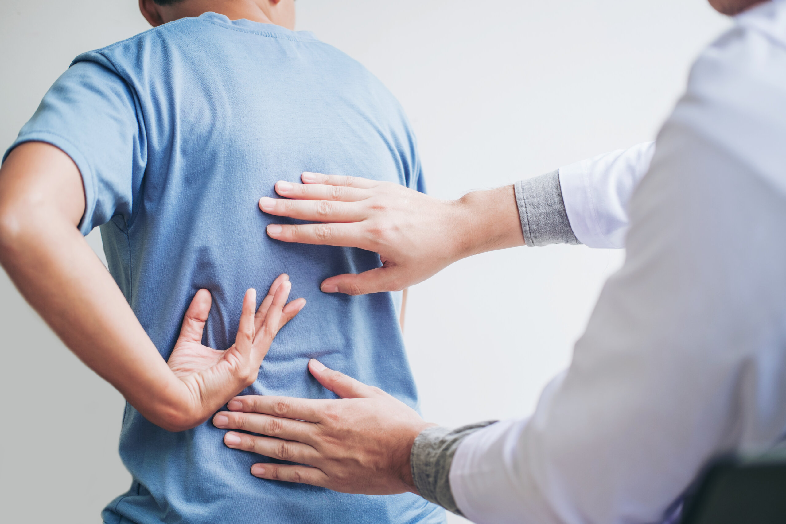 Doctor Conducting Back Exam with Patient Indicating Pain