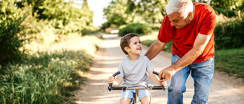 Grandfather Teaching Grandson to Ride Bike