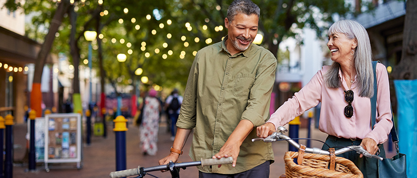 Older Couple Pushing Bikes in the City