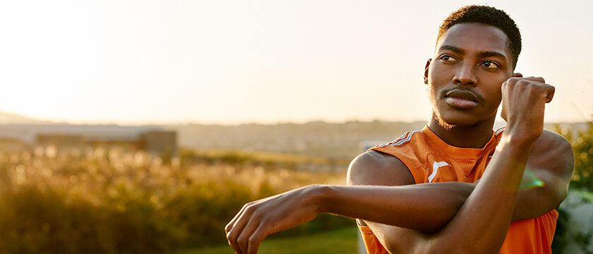 Young Black Man Stretching Arm Outdoors