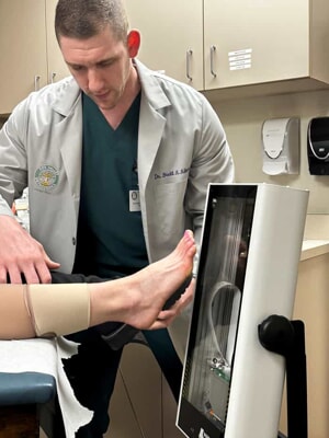 Podiatrist Dr. Brett Albert using a 3D digital foot scanner on a patient for custom orthotics at Fox Valley Orthopedics.